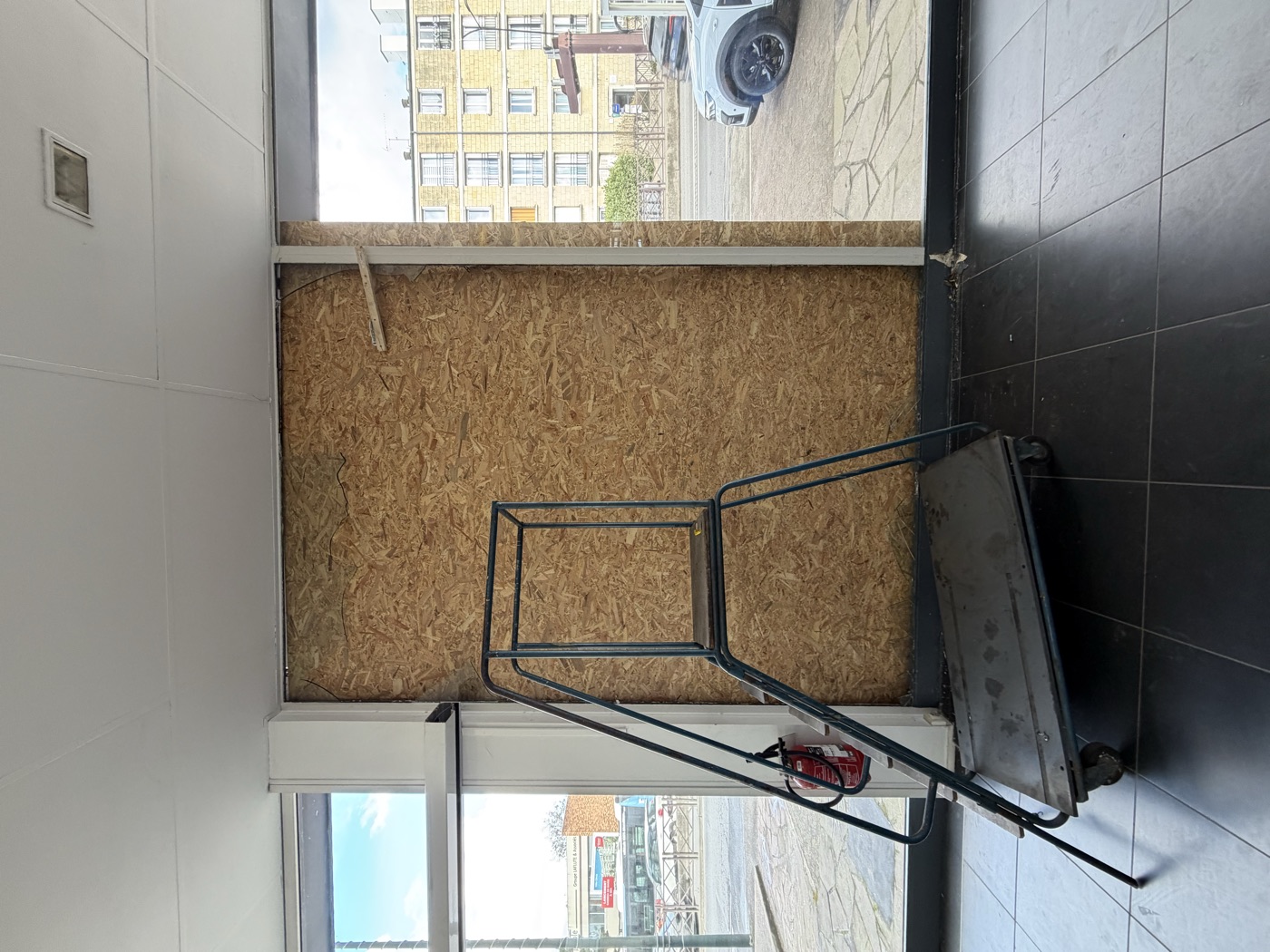 Mise en sécurité d'une vitrine après bris de glace Vitrine sécurisée par un panneau de bois après un bris de glace, par ETS Leroy Père & Fils